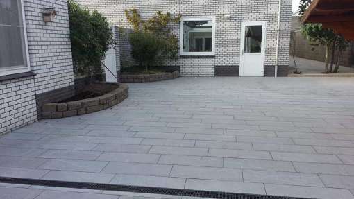 leggen van natuursteen pandangdark g85 in het straatwerk ligt een afwateringsgoot van zwart kunstof tuin aanleggen in tilburg ledeboerstraat 